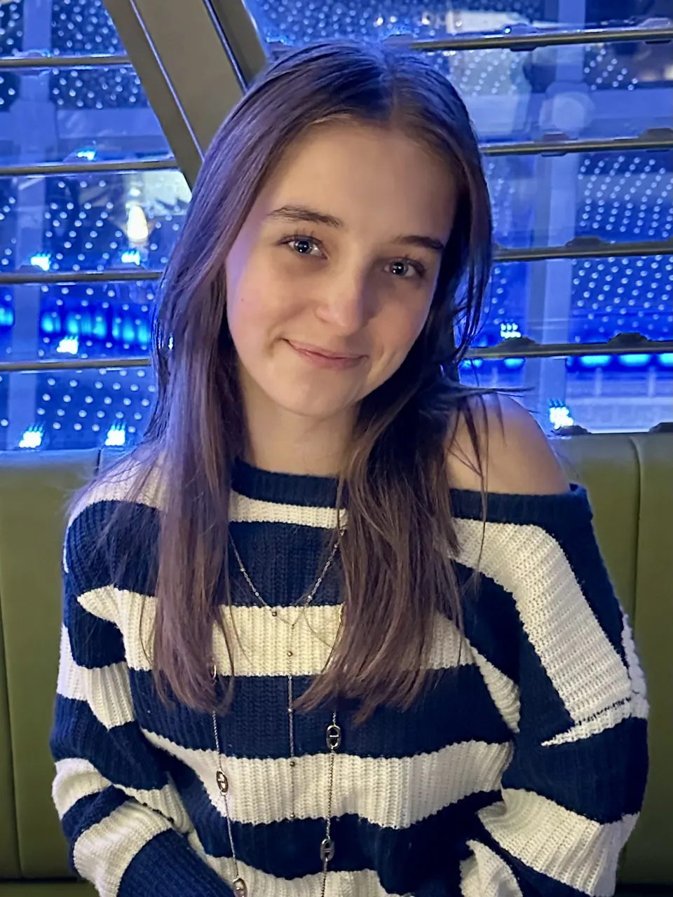 Manon Maindivide casual portrait in a navy and white striped sweater against blue lights