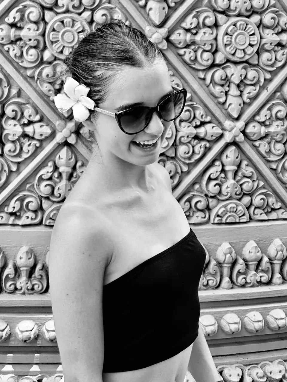 Manon Maindivide photo shoot in black and white, sunglasses and a flower in her hair, ornate wall