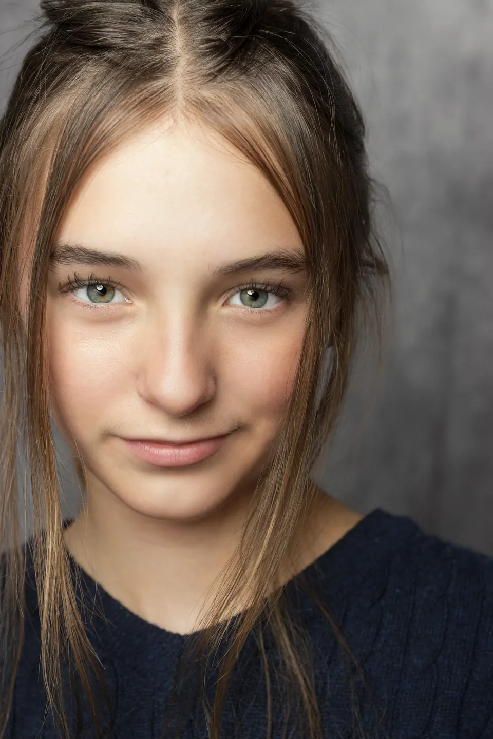 Manon Maindivide close-up headshot with natural light and a soft grey background