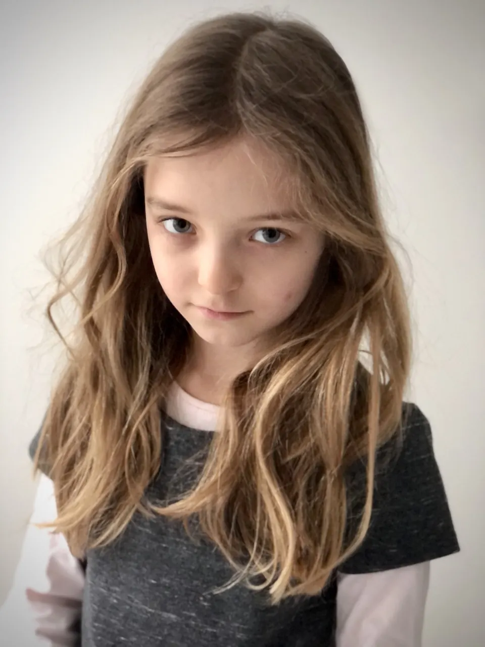 Manon Maindivide headshot with wavy hair and a serious gaze, wearing a grey T-shirt