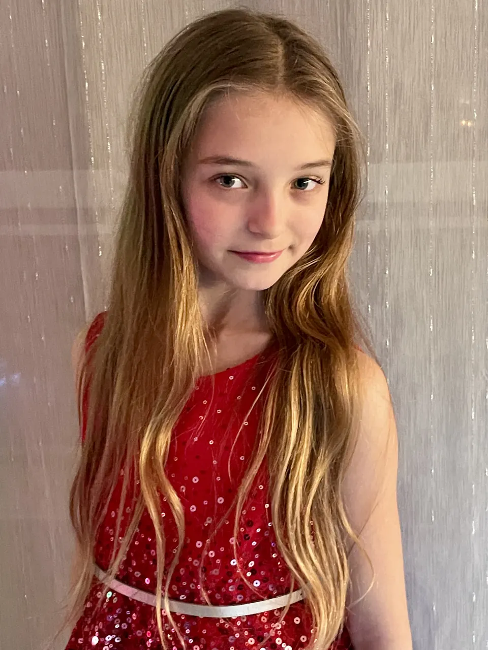 Manon Maindivide portrait in a red sequined dress with long wavy hair