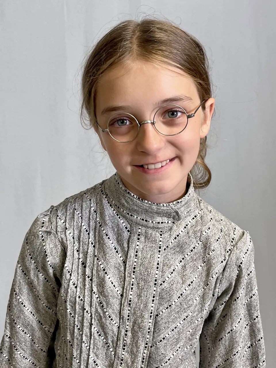 Manon Maindivide costume test with round wire glasses and a high-collared patterned blouse