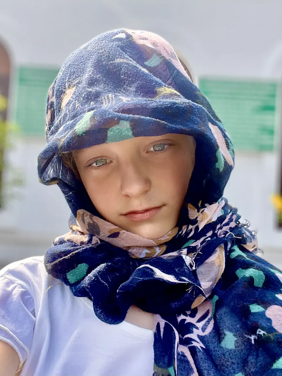 Manon Maindivide casual selfie wrapped in a blue patterned scarf and hood, eyes on the camera