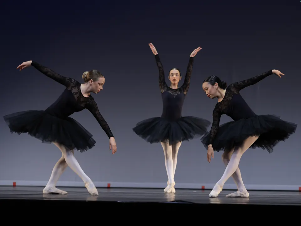 Manon Maindivide dance performance in a black tutu, in a trio of ballet dancers with raised arms