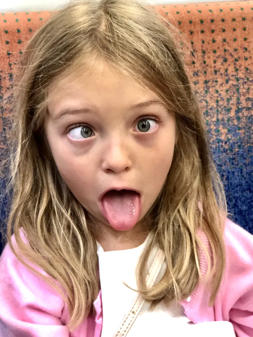 Manon Maindivide casual photo pulling a funny face with tongue out, wearing a pink hoodie