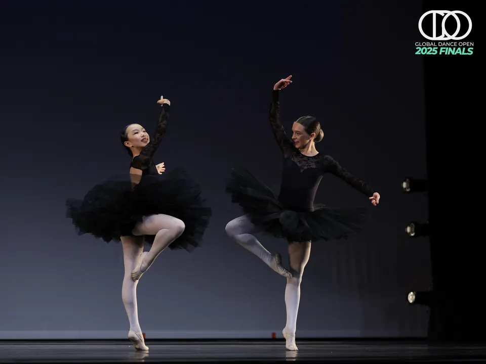 Manon Maindivide dance performance in a black tutu, en pointe beside another ballerina