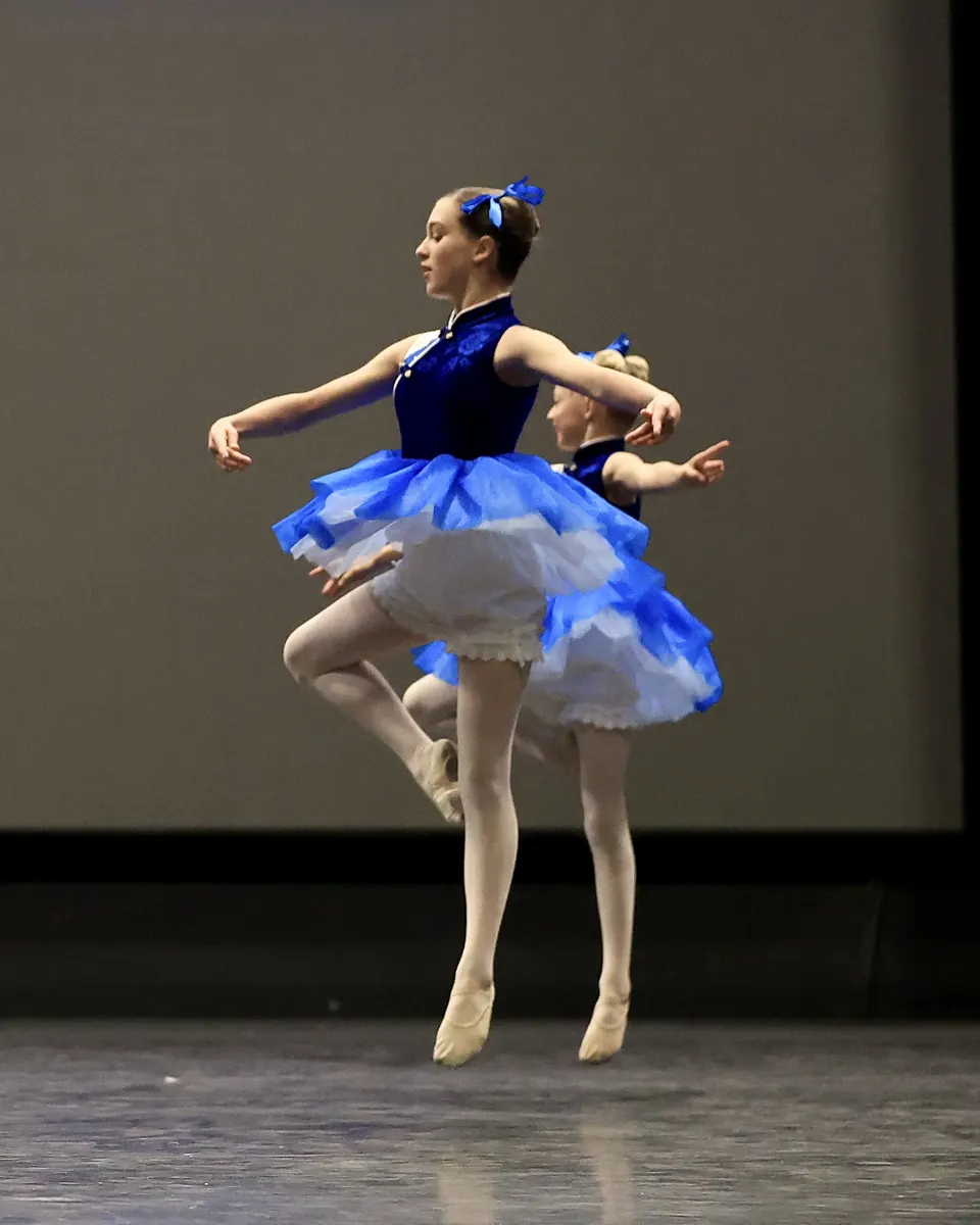 Manon Maindivide dance performance in a blue tutu with feather headpiece, en pointe