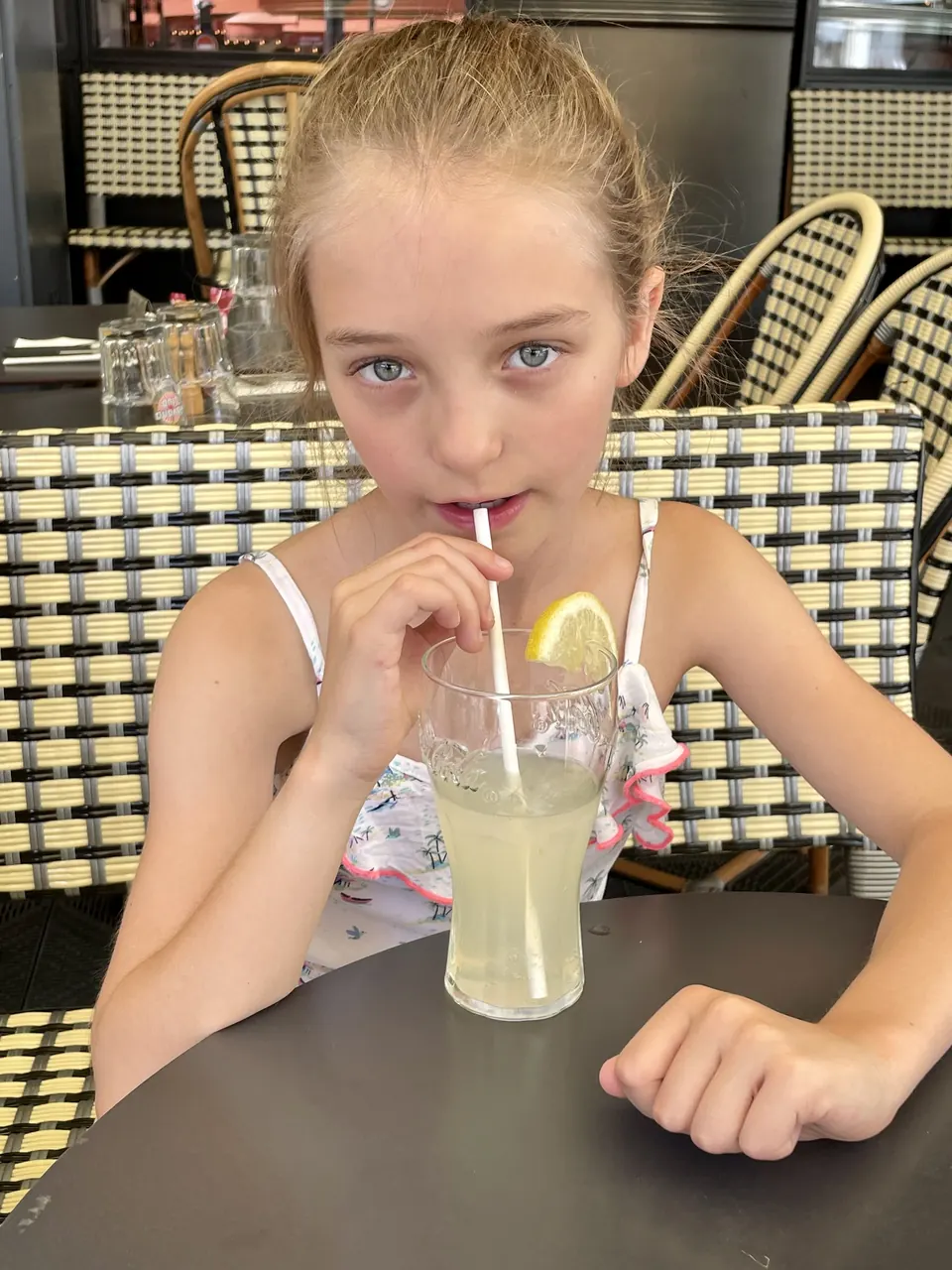 Manon Maindivide casual photo at a cafe table, sipping lemonade through a straw