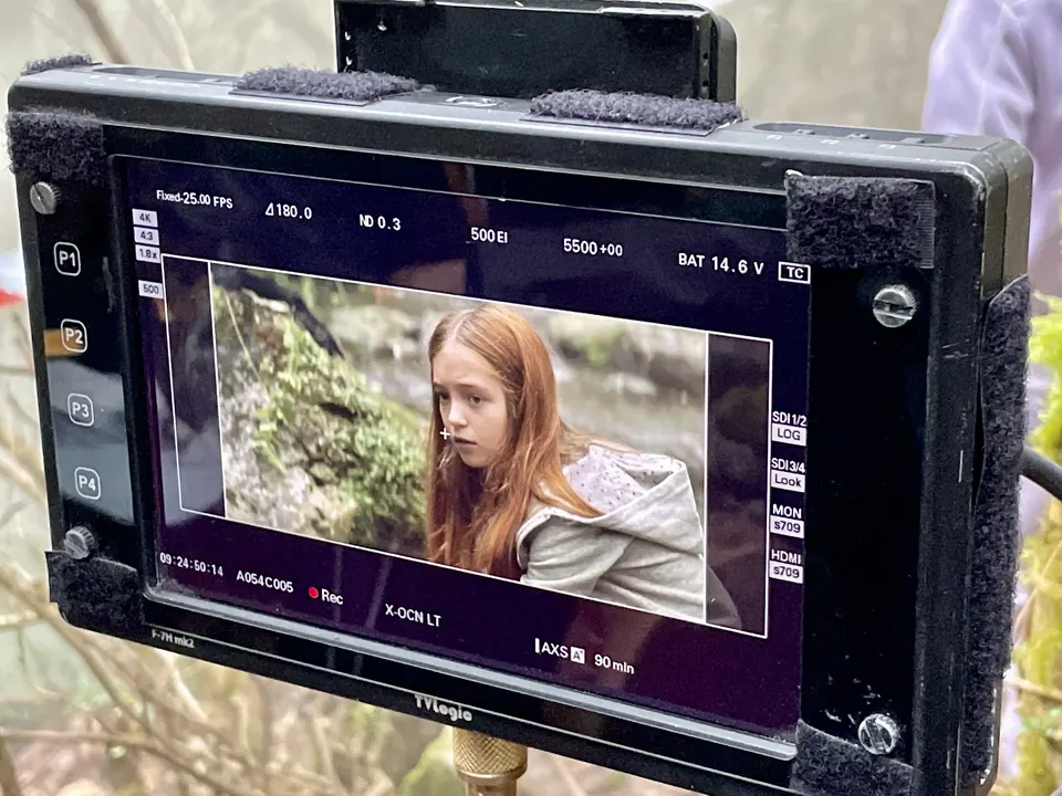 Manon Maindivide on set, camera monitor showing her in a grey jacket in an outdoor scene