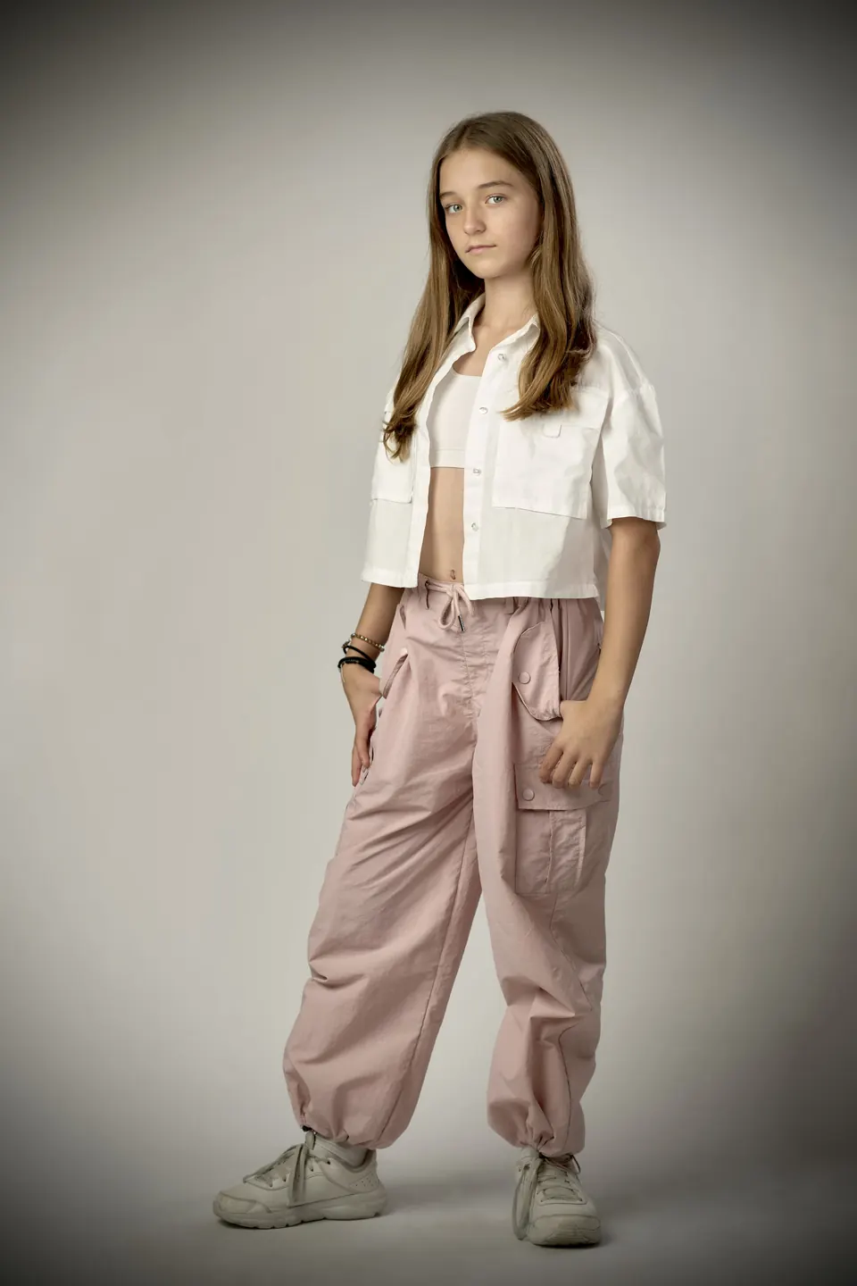 Manon Maindivide photo shoot full length in a white cropped shirt and pink cargo trousers