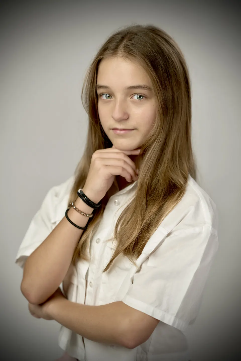 Manon Maindivide portrait in a white shirt, hand to her chin, gentle vignette lighting