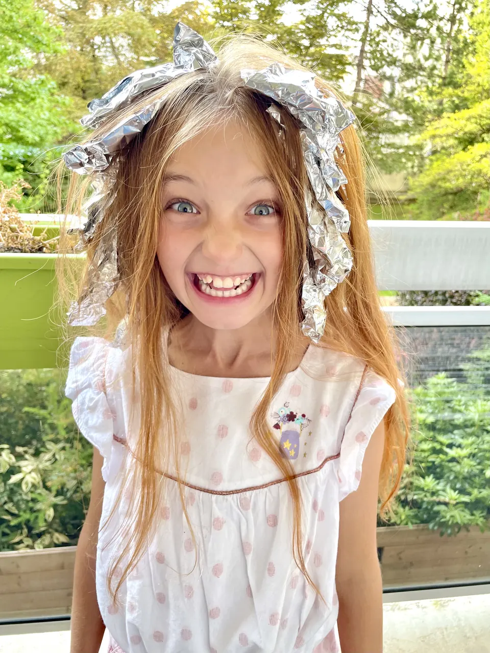 Manon Maindivide casual photo with a wide grin, foil wraps in her hair and a white polka dot top