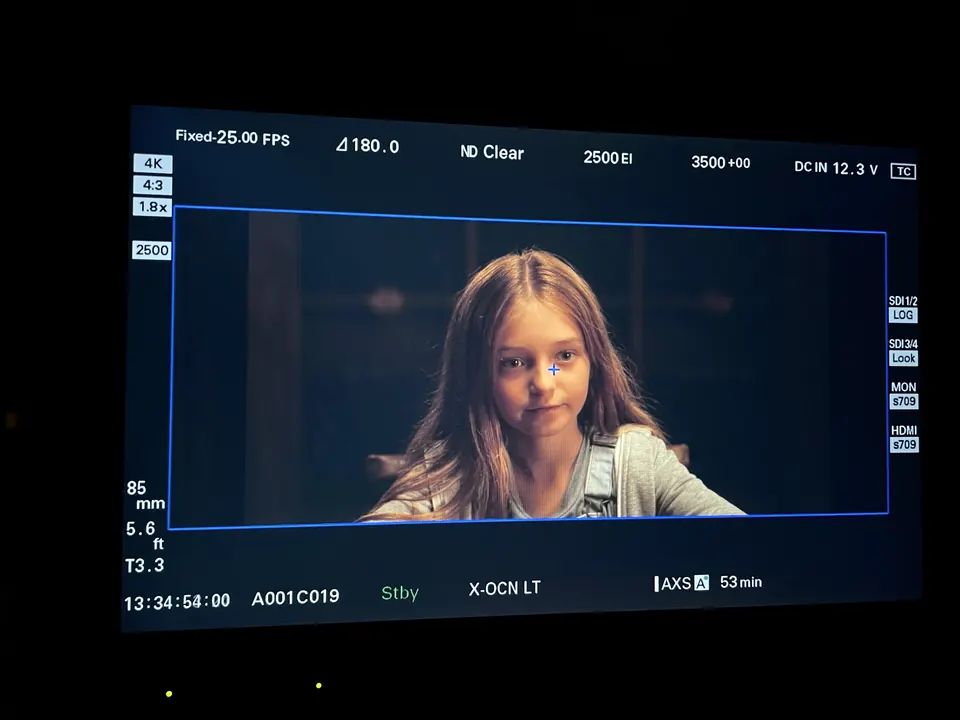 Manon Maindivide on set, a close shot of her smiling displayed on a camera monitor