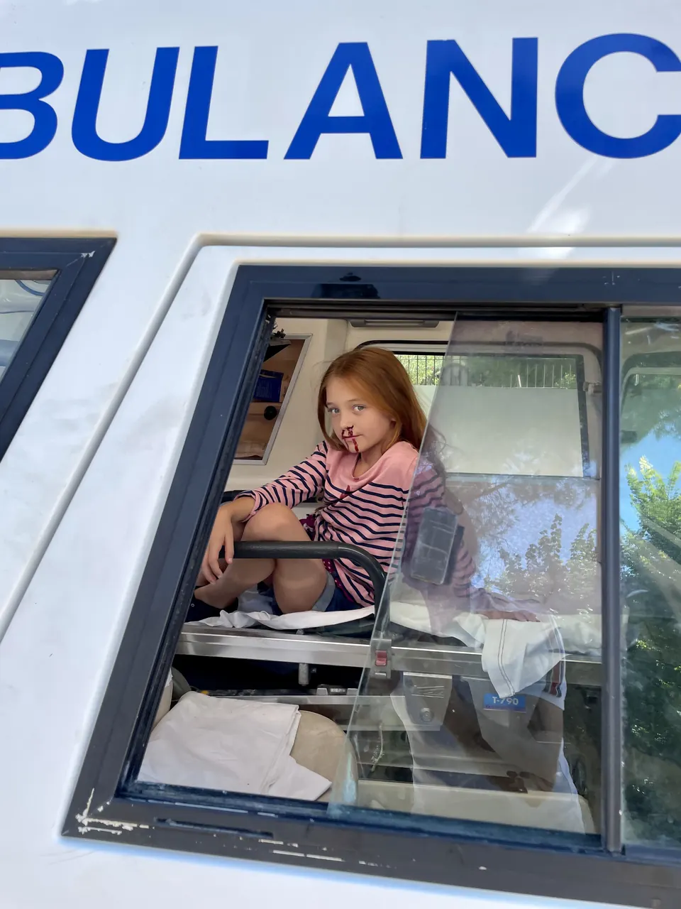 Manon Maindivide behind the scenes in a striped top, sitting inside an ambulance window