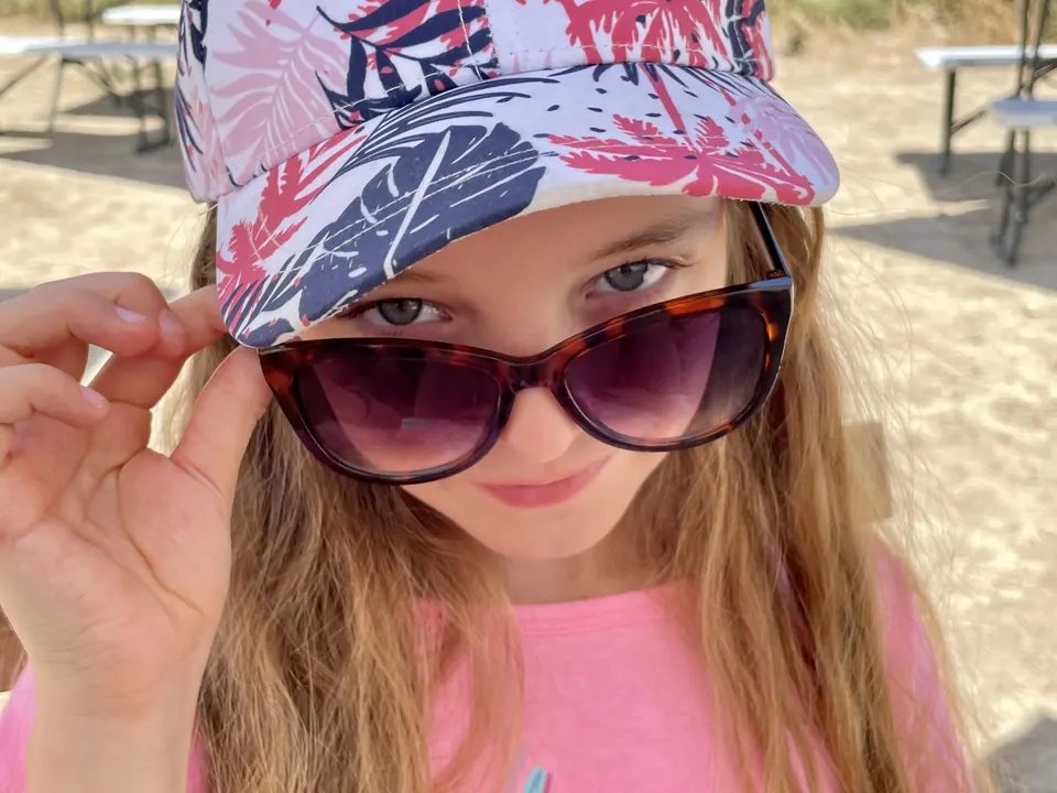 Manon Maindivide casual selfie in a patterned cap and tortoiseshell sunglasses, pink top