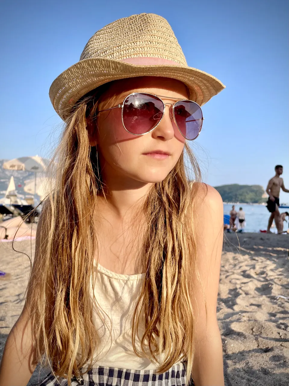 Manon Maindivide casual photo on a beach in a straw hat and pink tinted sunglasses