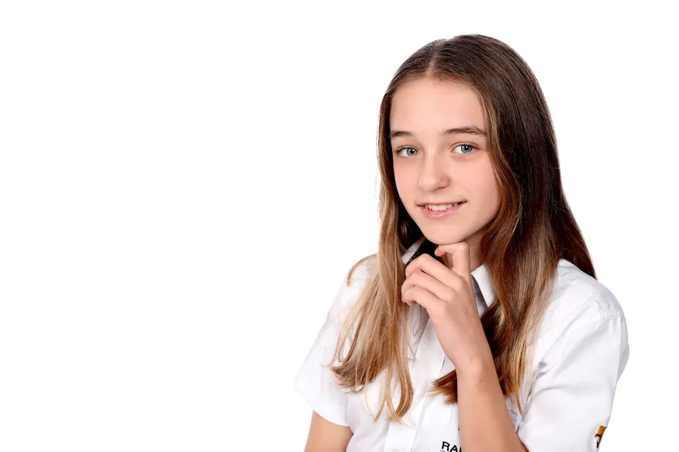 Manon Maindivide headshot in a white shirt, hand under her chin on a plain white background
