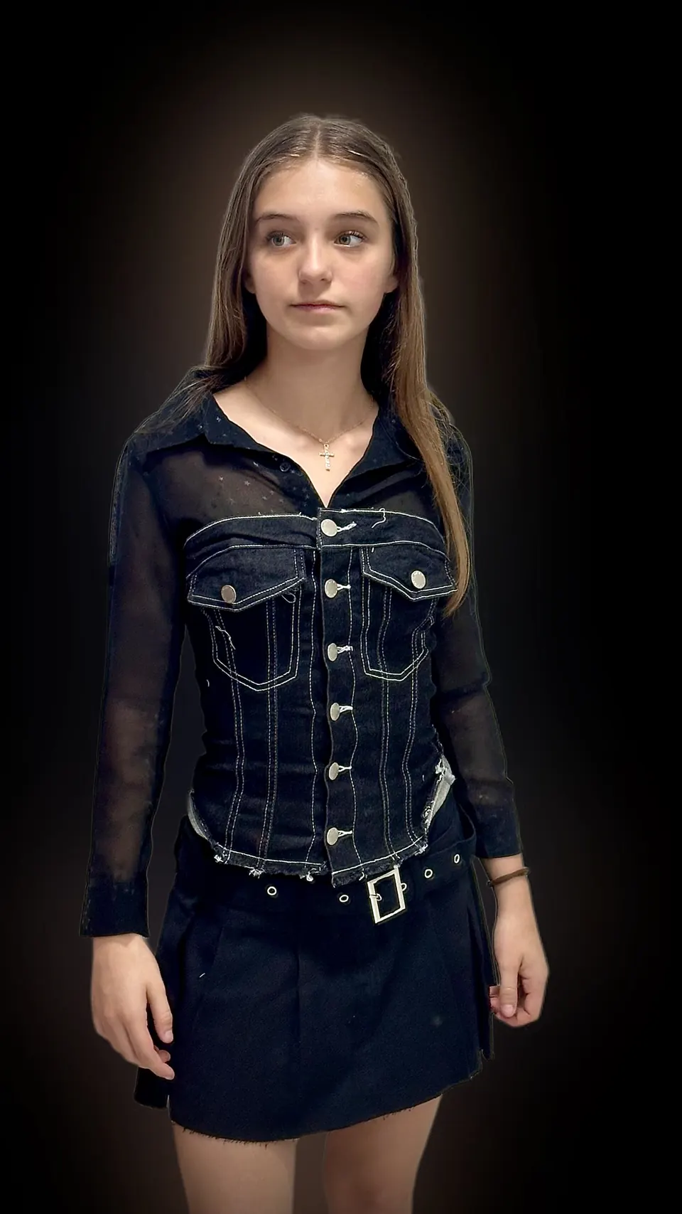 Manon Maindivide portrait in a black denim corset top and skirt, spotlit against a dark background