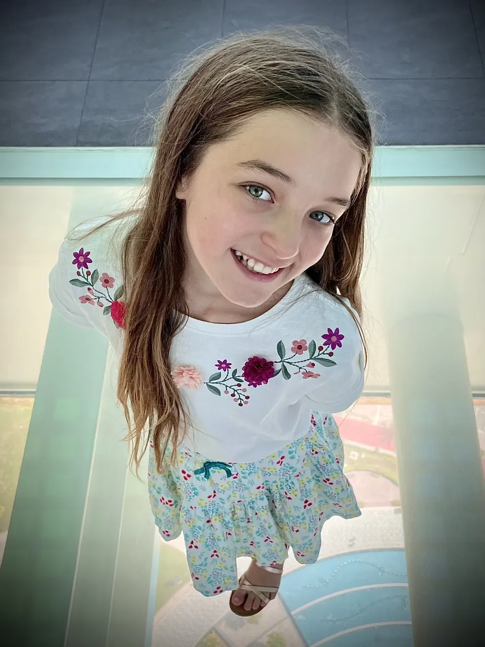 Manon Maindivide casual portrait from above in an embroidered white top, smiling