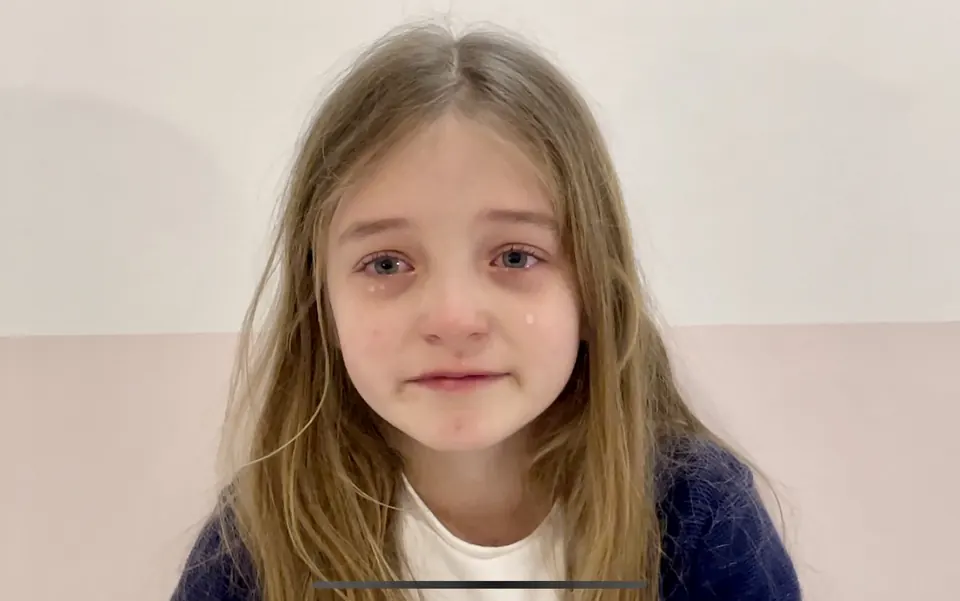 Manon Maindivide casual portrait as a young child, tearful expression, in a navy cardigan